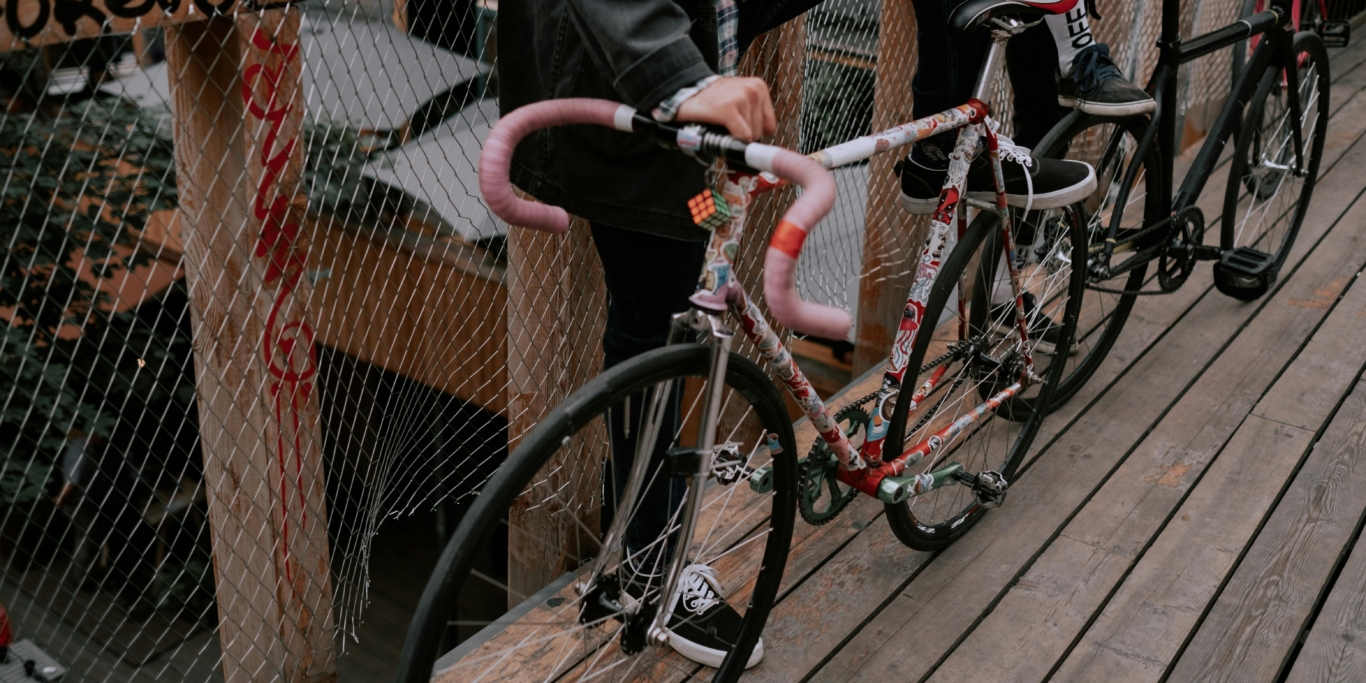 two people standing next to their bikes on a bridge