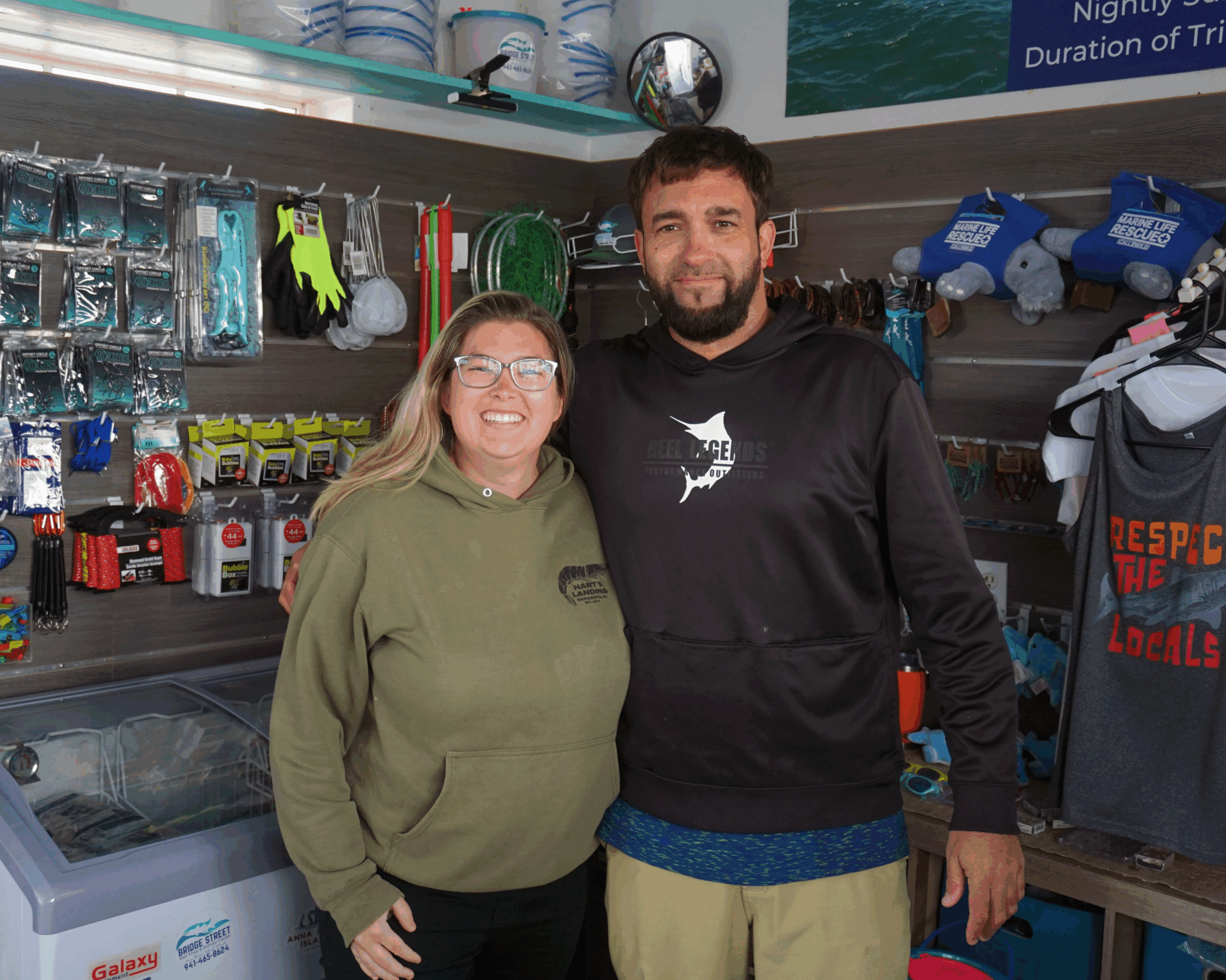 A woman and man pose in a bait shop