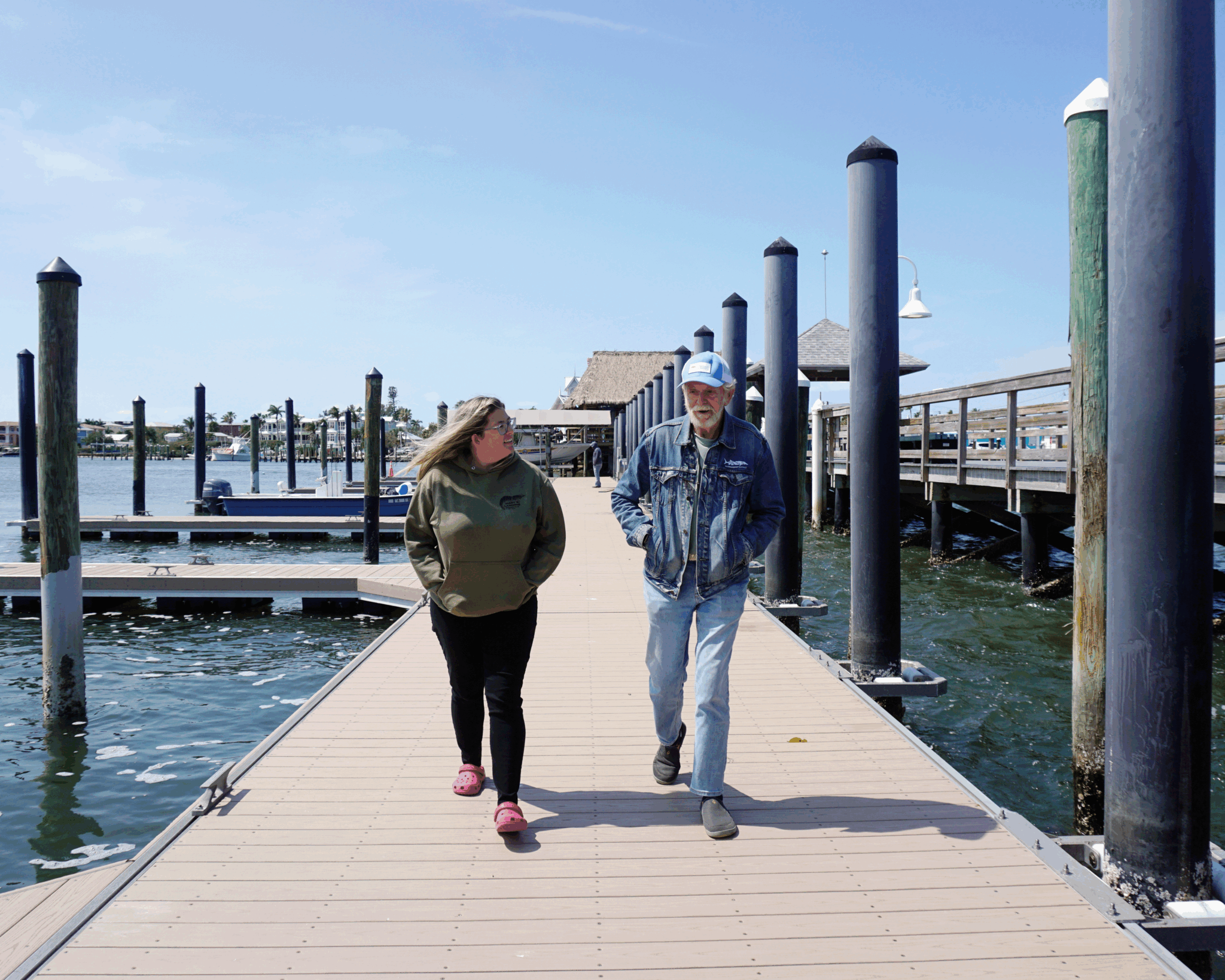 A man and a woman walk alongside each other on a floating dock