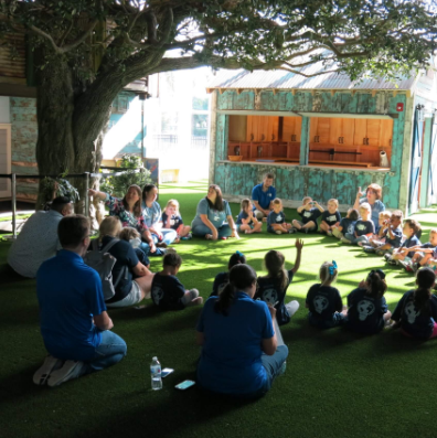 children listening to stories under a tree