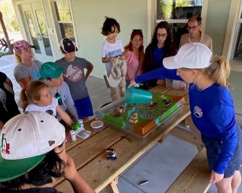 students from Unidos Now looking at a watershed demonstration